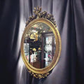 No se trata de un espejo corriente: su valor está en la talla, en el acabado dorado y en la forma en la que su decoración floral enmarca la luna central.