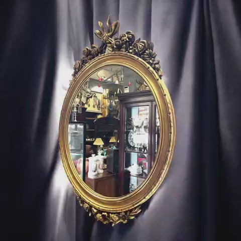 No se trata de un espejo corriente: su valor está en la talla, en el acabado dorado y en la forma en la que su decoración floral enmarca la luna central.